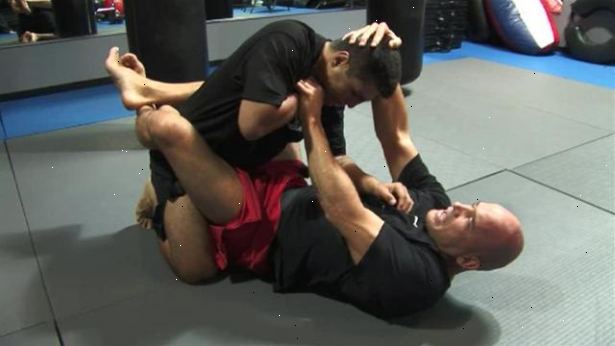 Hvordan søke en trekant choke fra åpen vakt i mixed martial arts. Begynn med å ligge på ryggen med bena fra hverandre.