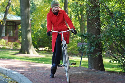 Slik demonterer fra en sykkel. Fra sittende stilling, pedal på den ene siden og deretter lene seg frem for å stå opp på den pedalen mens du løfter baken av setet.